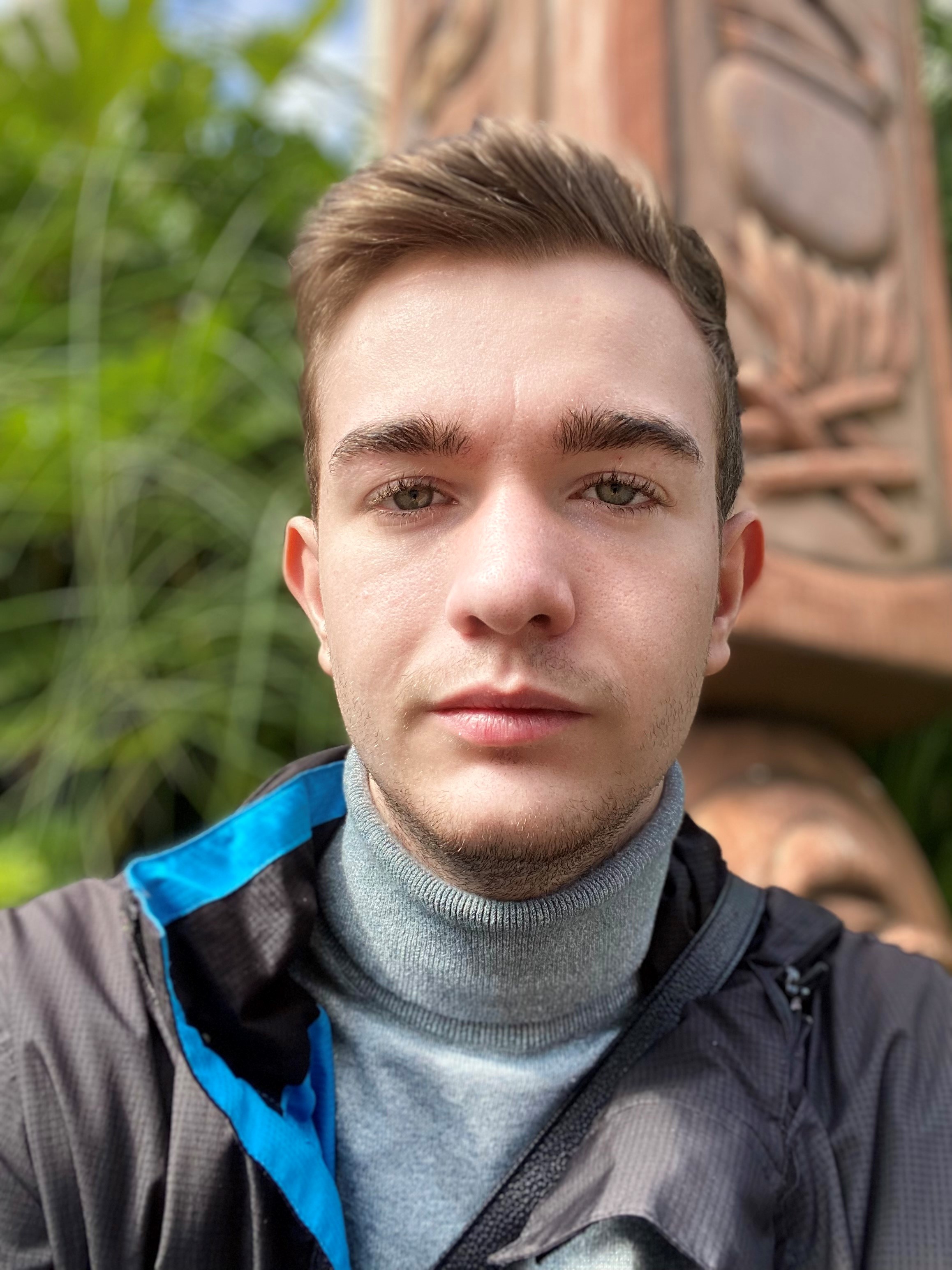 Image description: Picture of Shaun Davis. 19 year old male, brown haired, wearing a oslo gray highneck, and a thin black coat with blue lining inside.